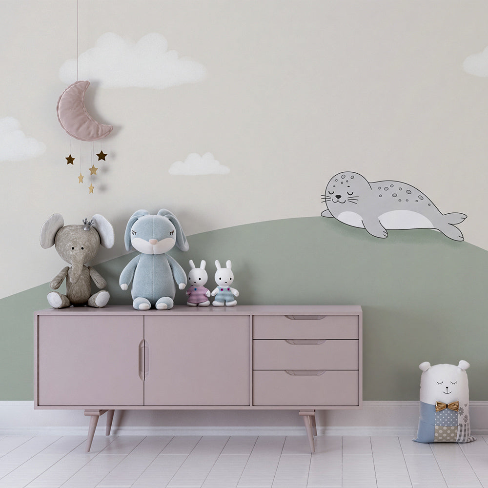 Baby room featuring sleeping seal wallpaper with soft green hill and cloud design