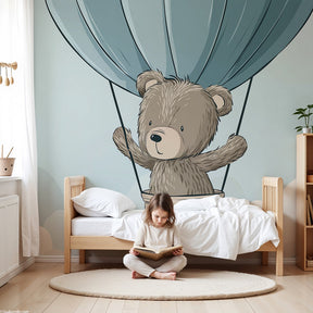 Bear hot air balloon mural wallpaper in soft blue nursery with white crib by Kids-Mundo