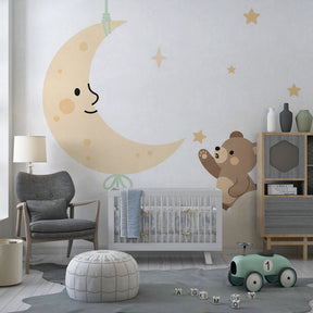 Bear reaching for smiling moon mural wallpaper in soft beige toddler room decor
