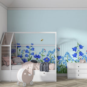 Sunny meadow mural wallpaper transforming kids room into nature paradise with blue blooms and bees