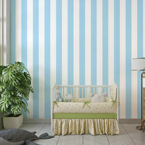 Pastel blue striped wallpaper creating calm children's bedroom decor with wooden furniture