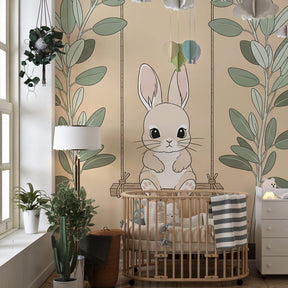 Soft green and beige bunny mural wallpaper complementing light wood nursery furniture