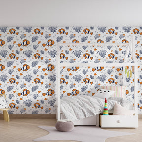 Colorful clownfish and coral mural wallpaper creating underwater theme in children's bedroom
