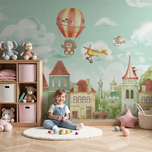 Kids-Mundo enchanted balloon village wall mural in a soft pastel nursery with a cot