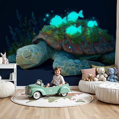 Kids-Mundo turtle wall mural in a dark nursery with a cot beneath glowing reef fish