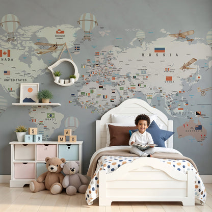 Kids-Mundo grey world map wall mural in a nursery, striped balloons drifting above a soft cream cot.