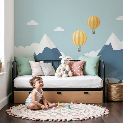 Kids-Mundo hot air balloon mountain wall mural in a calm nursery with a cot and soft neutral decor