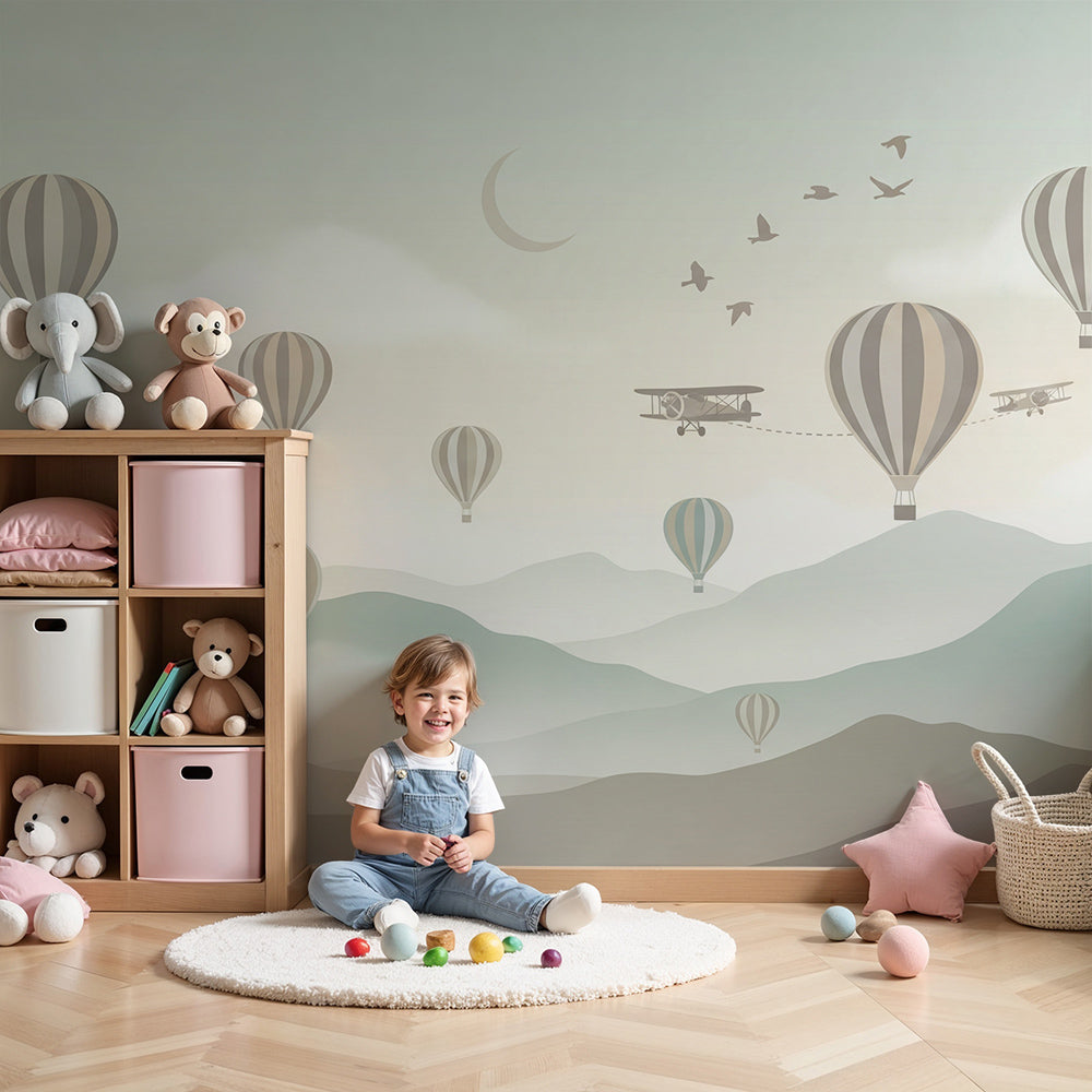 Kids-Mundo hot air balloon and biplane sky wall mural styled above a cot in a soft green nursery