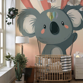 Pink and beige koala balloon mural wallpaper with natural wood furniture in nursery