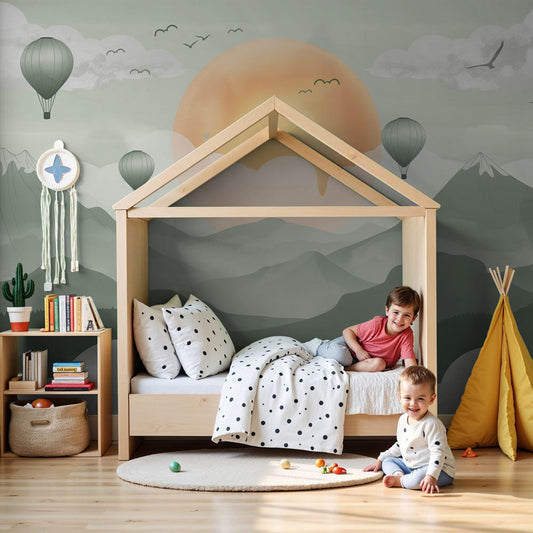 Kids-Mundo misty mountain and hot air balloon wall mural styled in a soft sage-green nursery with a cot