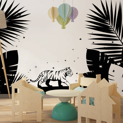 Kids-Mundo monochrome jungle wall mural styled behind a reading chair and books in a playroom.