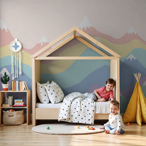 Pastel mountain mural wallpaper with rainbow clouds in modern kids nursery by Kids-Mundo