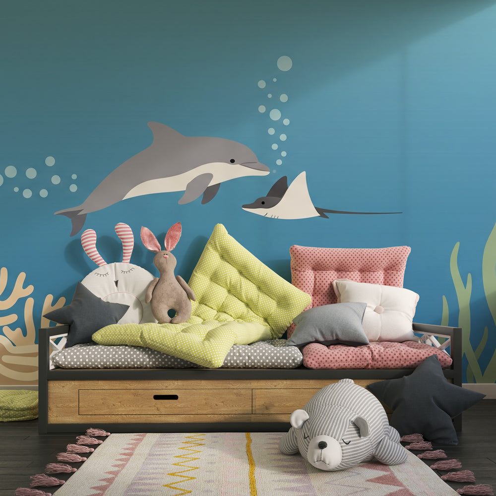 Coral reef mural wallpaper featuring dolphins and rays in bright kids playroom setting