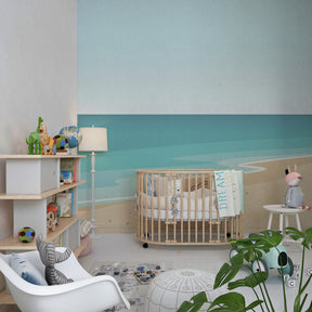 Calming ocean themed nursery with turtle beach mural wallpaper and soft furnishings