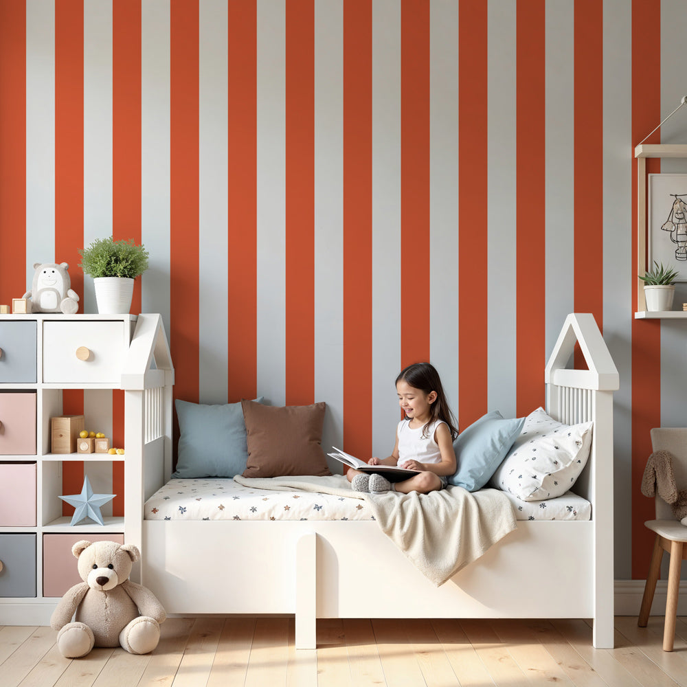 Kids-Mundo orange and white stripe wall mural behind a cot in a sunny, warm nursery.