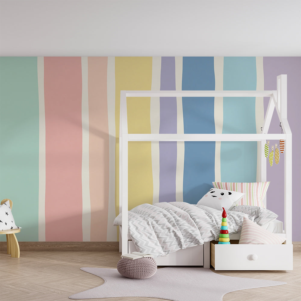 Kids-Mundo pastel rainbow stripes wall mural styled behind a bed in a cheerful kids' bedroom