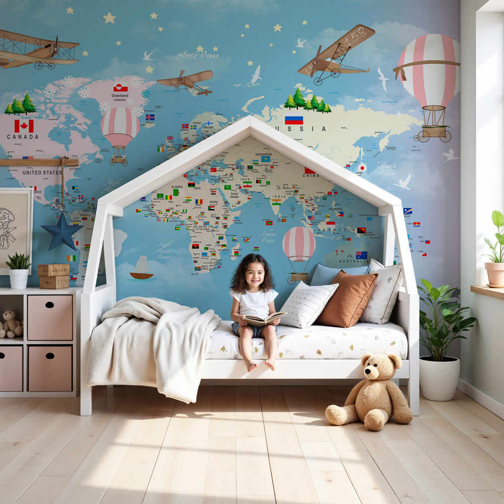 Kids-Mundo pastel world map wall mural in a nursery, hot air balloons and flags floating above the cot.