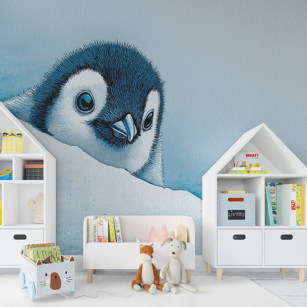 Arctic penguin mural wallpaper in cozy toddler room with light wooden furniture and blue accessories
