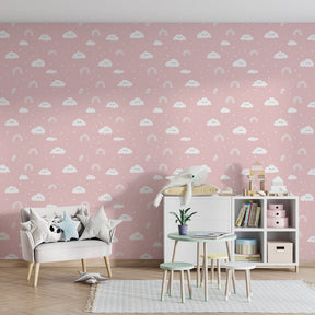 Pink rainbow wallpaper transforming children's bedroom into magical space with cloud motifs