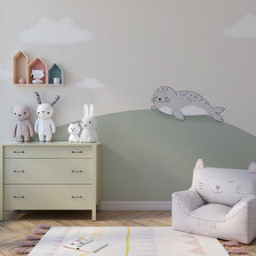 Complete nursery setup with sleeping seal mural wallpaper and matching pastel accessories