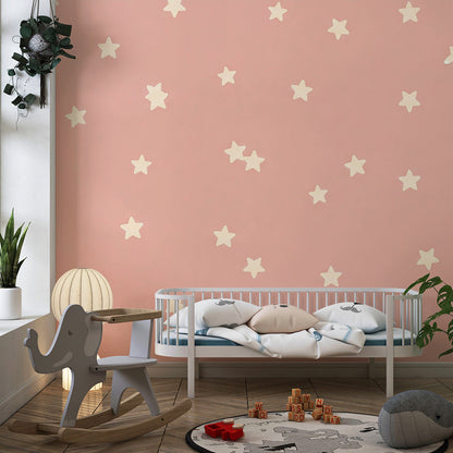 Kids-Mundo pink star wall mural on a feature wall in a toddler's bedroom with soft toys nearby.