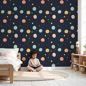 Space planets mural wallpaper with smiling faces in pastel nursery by Kids-Mundo