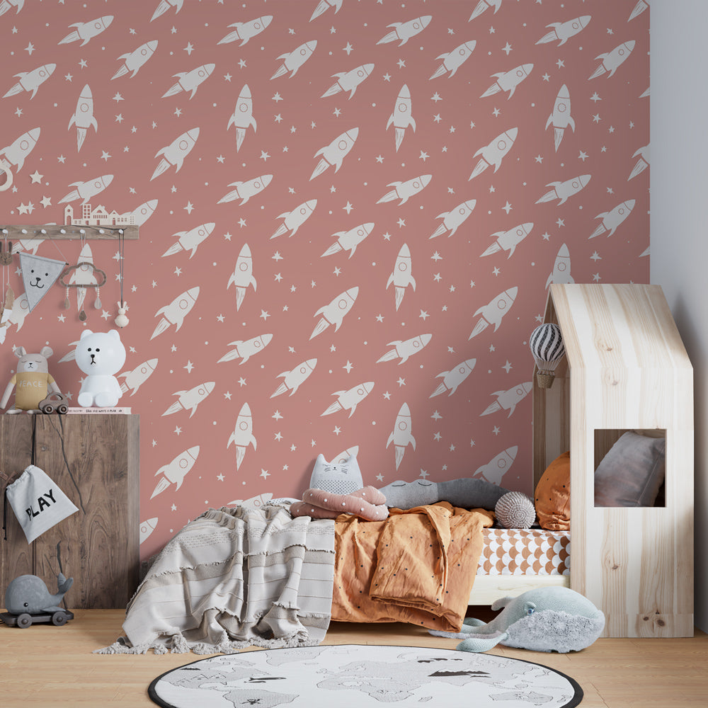 White rockets on pink mural wallpaper transforming children's bedroom into cosmic adventure space