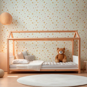 Orange and yellow sunshine wallpaper creating warm nursery atmosphere with wooden furniture