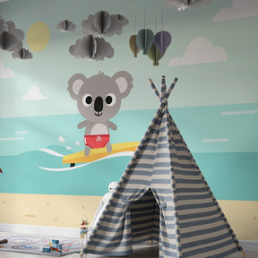 Cheerful koala surfer mural wallpaper bringing summer vibes to colorful kids playroom space