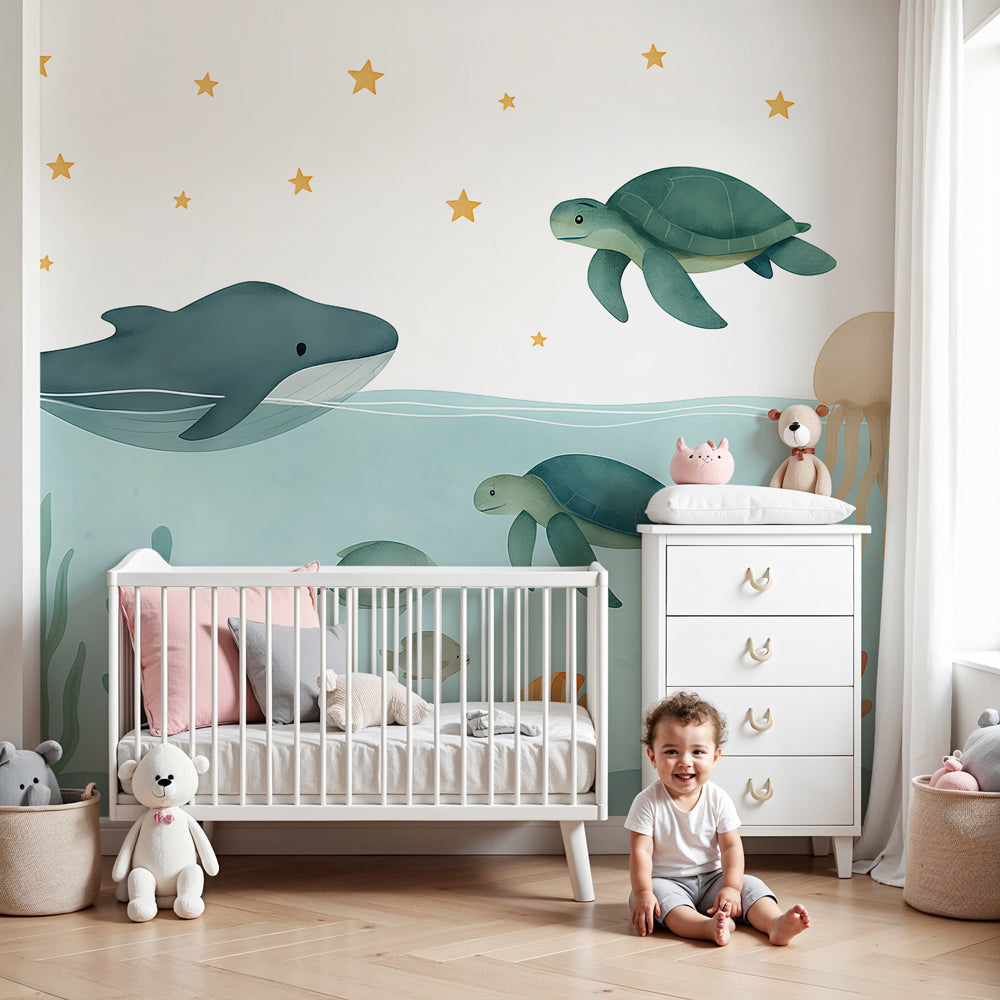 Kids-Mundo whale and sea turtle ocean wall mural in a soft blue nursery with cot and rug
