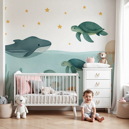 Kids-Mundo whale and sea turtle ocean wall mural in a soft blue nursery with cot and rug